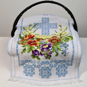 Easter basket cover with blue cross embroidery and spring floral design