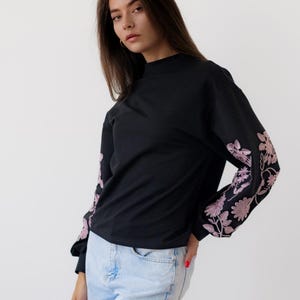 Black sweatshirt with pink floral embroidered sleeves