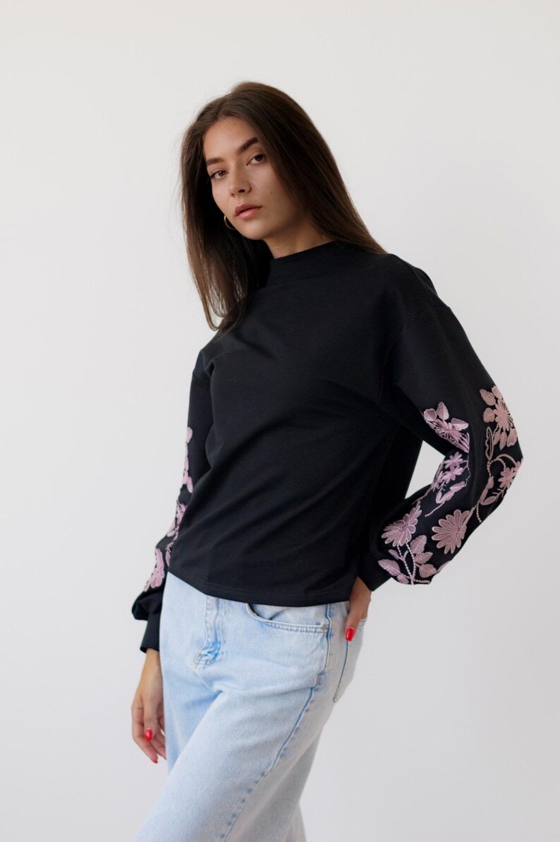 Black sweatshirt with pink floral embroidered sleeves