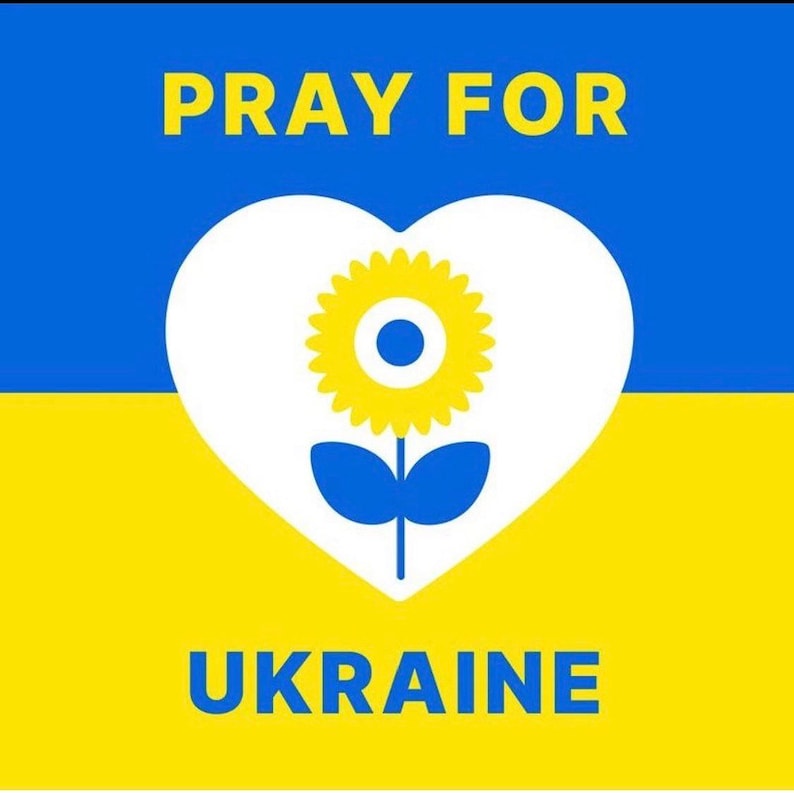 K&ouml;nnte beinhalten: Grafik mit den Worten "PRAY FOR UKRAINE" in gelbem Text auf blauem und gelbem Hintergrund. Ein wei&szlig;es Herz enth&auml;lt eine gelbe Sonnenblume mit blauen Bl&auml;ttern.