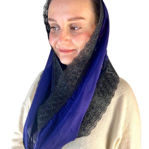 May include: A royal blue head covering with black lace trim. The lace trim is a delicate pattern of circles and swirls.