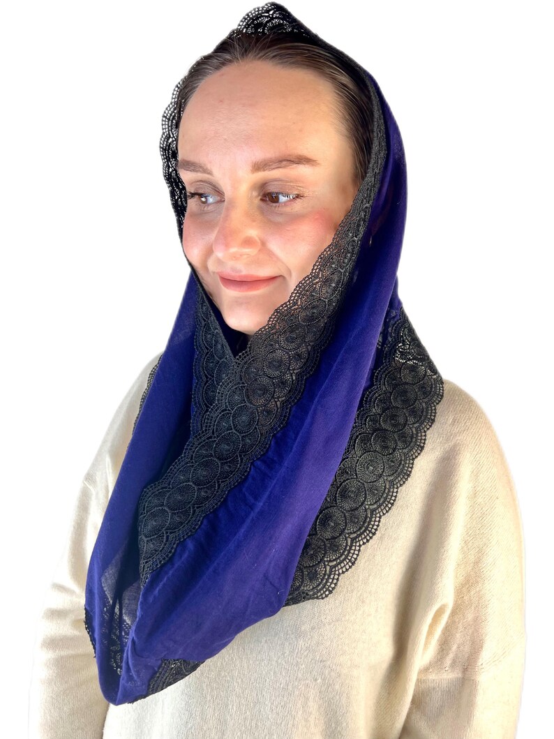 May include: A royal blue head covering with black lace trim. The lace trim is a delicate pattern of circles and swirls.