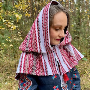 May include: A traditional style head covering with a red and white patterned design. The garment is worn over the head and shoulders, featuring intricate embroidery and a tassel. The text "Style 1" is in the upper left corner.