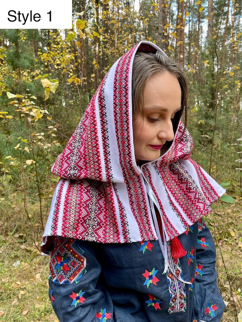 May include: A traditional style head covering with a red and white patterned design. The garment is worn over the head and shoulders, featuring intricate embroidery and a tassel. The text "Style 1" is in the upper left corner.