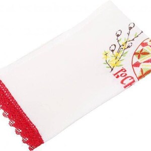 Peut inclure: Serviette de cuisine blanche avec une bordure en dentelle rouge brod&eacute;e et un motif d'&oelig;uf de P&acirc;ques brod&eacute; color&eacute;. Le motif comprend une fleur jaune et le mot "Joyeux" en rouge.