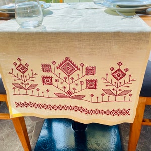 Linen table runner with red embroidered floral pattern
