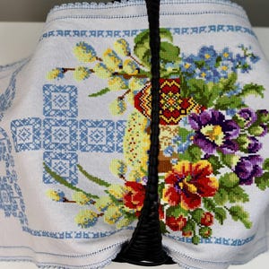Easter basket cover with blue cross embroidery and spring floral design