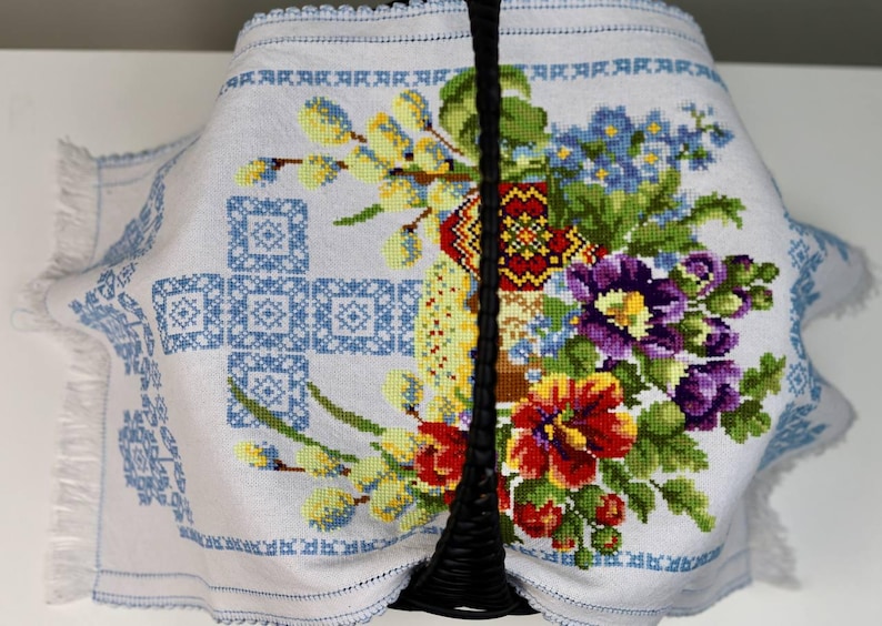 Easter basket cover with blue cross embroidery and spring floral design