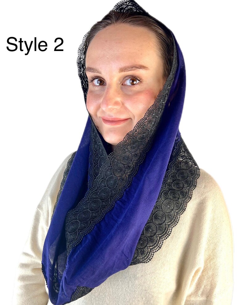 May include: A blue fabric head covering with black lace trim. The lace trim is on the edge of the fabric and is a decorative element.