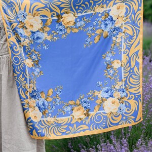 May include: A blue and gold floral patterned scarf with a yellow and blue floral design. The scarf is made of a soft, silky material and has a delicate, feminine feel.