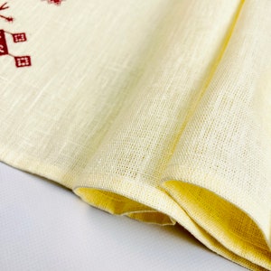Linen table runner with red embroidered floral pattern
