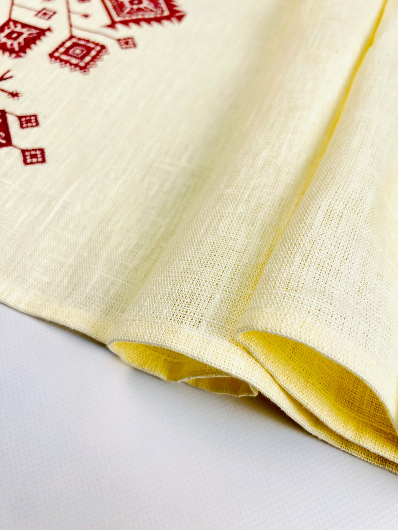 Linen table runner with red embroidered floral pattern