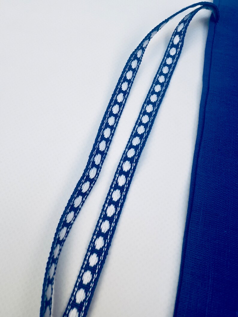 K&ouml;nnte beinhalten: Eine blaue Stofftasche mit einem wei&szlig;en gepunkteten Kordelzug.