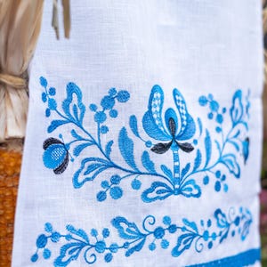 White linen towel with blue floral embroidery