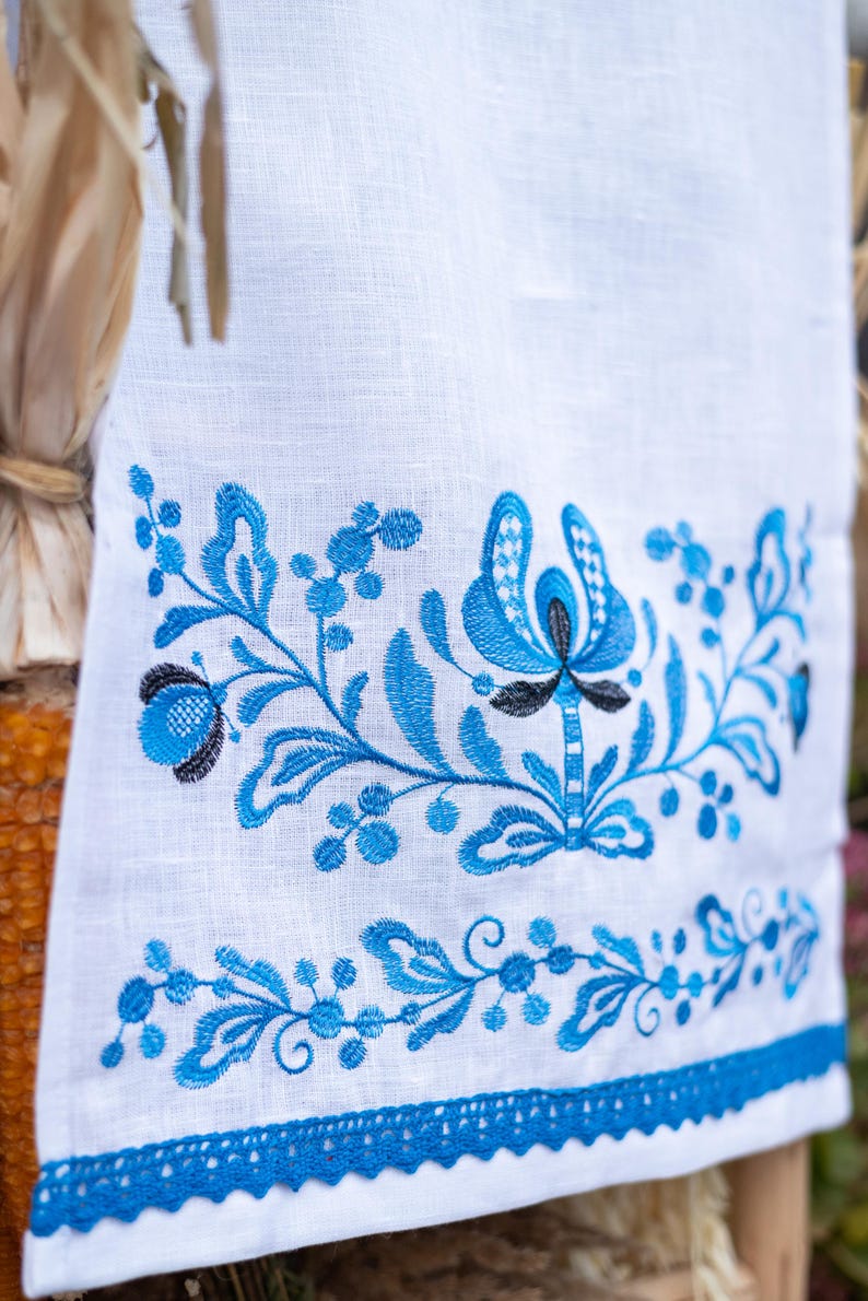 White linen towel with blue floral embroidery