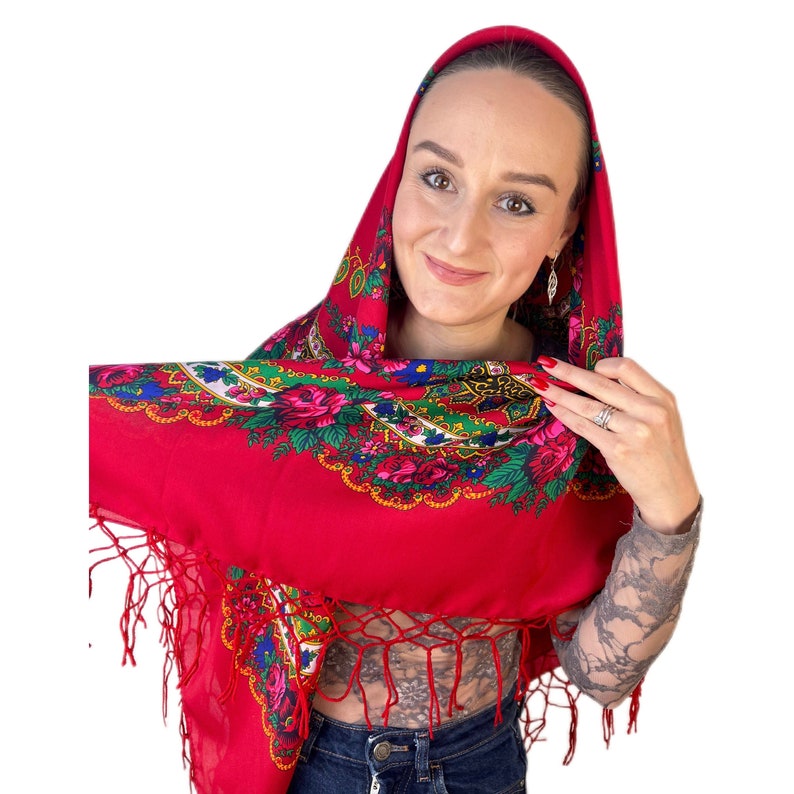 Puede incluir: Un pa&ntilde;uelo rojo con estampado floral y flecos. El pa&ntilde;uelo lo lleva una persona con un tatuaje en el cuello y el brazo.
