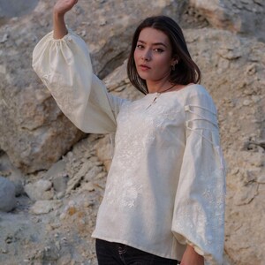 Ivory linen blouse with puffy sleeves and intricate white embroidery