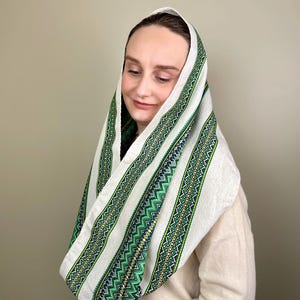 Könnte beinhalten: Ein weißes Kopftuch mit grüner, gelber und blauer geometrischer Stickerei. Das Tuch ist über Kopf und Schultern drapiert. Der Text "Style 1" befindet sich in der oberen linken Ecke.