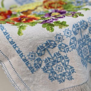 Easter basket cover with blue cross embroidery and spring floral design