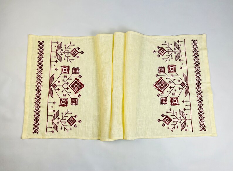 Linen table runner with red embroidered floral pattern