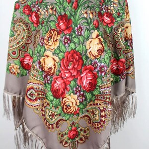 Peut inclure: Un foulard en soie gris avec un motif floral compos&eacute; de roses rouges, jaunes et vertes. Le foulard a une bordure &agrave; franges.