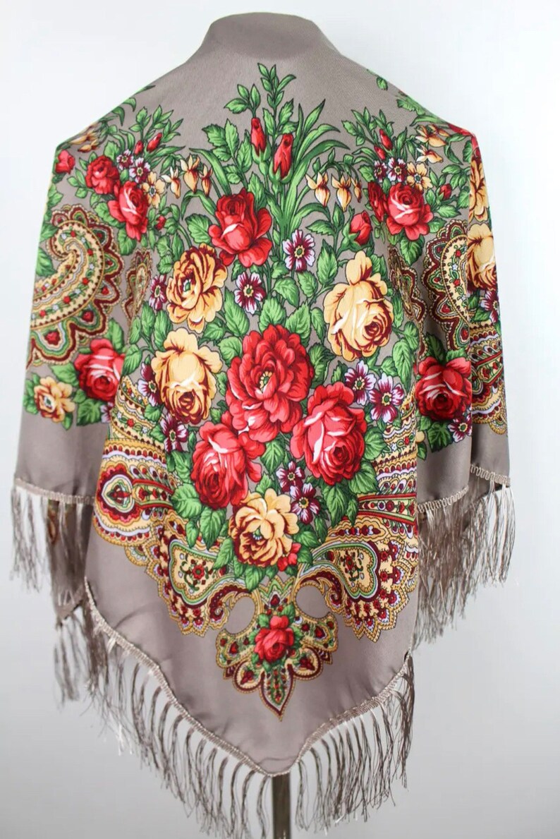 Peut inclure: Un foulard en soie gris avec un motif floral compos&eacute; de roses rouges, jaunes et vertes. Le foulard a une bordure &agrave; franges.
