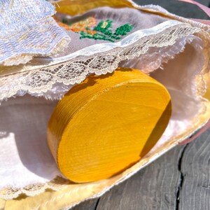 Puede incluir: Un c&iacute;rculo de madera amarillo con un borde de encaje blanco y un patr&oacute;n floral en la tela.