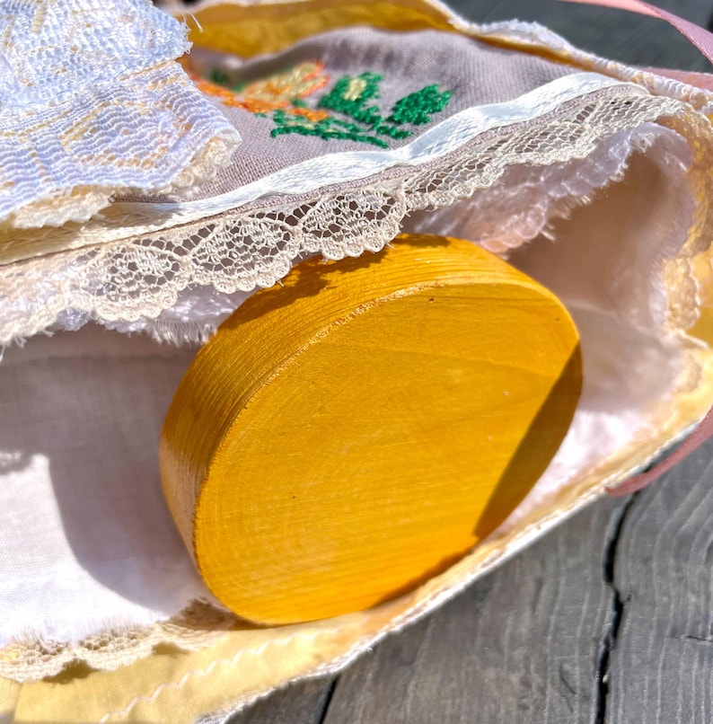 Puede incluir: Un c&iacute;rculo de madera amarillo con un borde de encaje blanco y un patr&oacute;n floral en la tela.