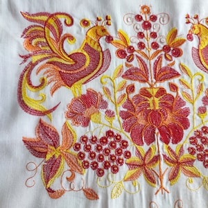 May include: Embroidered design featuring two stylized birds with yellow, orange, and red details. The birds are surrounded by floral motifs with red, orange, and yellow flowers and leaves.