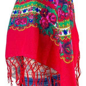 Puede incluir: Un chal rojo con un patr&oacute;n floral y flecos. El chal tiene un dise&ntilde;o tradicional con colores rojo, verde, amarillo, azul y blanco.