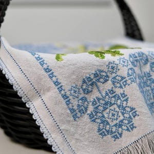 Easter basket cover with blue cross embroidery and spring floral design