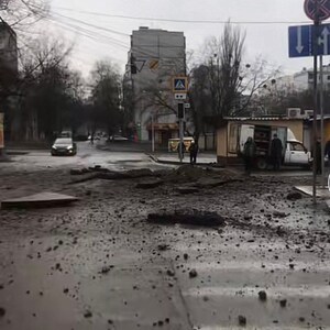 K&ouml;nnte beinhalten: Eine Stra&szlig;enszene in Charkiw, Ukraine, mit dem Datum 30. M&auml;rz im Himmel. Die Stra&szlig;e ist besch&auml;digt, mit Tr&uuml;mmern auf dem nassen Asphalt. Geb&auml;ude und B&auml;ume s&auml;umen die Stra&szlig;e.