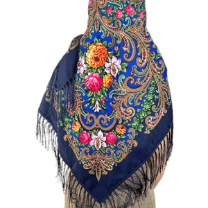 Peut inclure: Un foulard bleu &agrave; motifs paisley avec des motifs floraux et des franges noires.