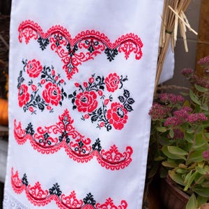 Handmade embroidered towel with red rose motifs and lace trim