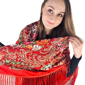 May include: A red shawl with a floral pattern and fringe. The shawl is made of a soft, lightweight fabric and is perfect for adding a touch of elegance to any outfit.