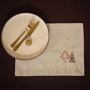 Christmas table napkin with embroidered gingerbread house design