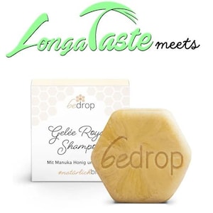 May include: A hexagonal shaped bar of yellow soap with the word "bedrop" printed on it. The soap is sitting on top of a white box with the words "Gelée Royale Shampoo" and "Mit Manuka Honig und #natürlichbio" printed on it.
