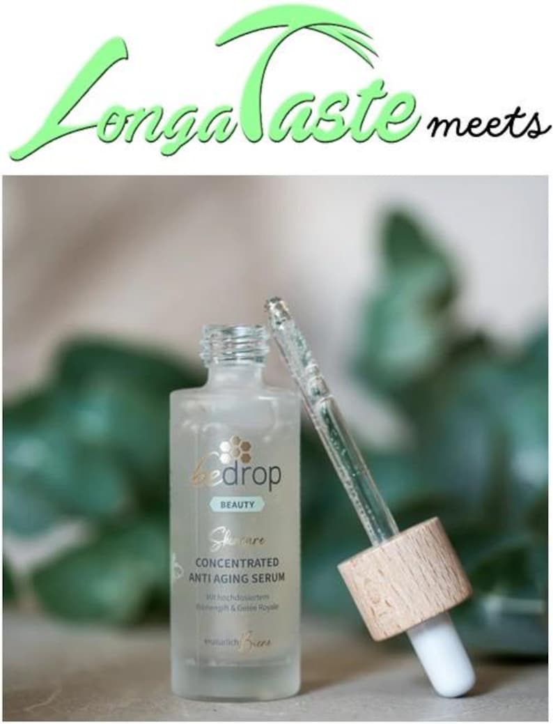 May include: A clear glass bottle of Bedrop Beauty concentrated anti-aging serum with a dropper. The bottle has a light green label with gold text and a wooden cap. The text "Longa Taste meets" is at the top.