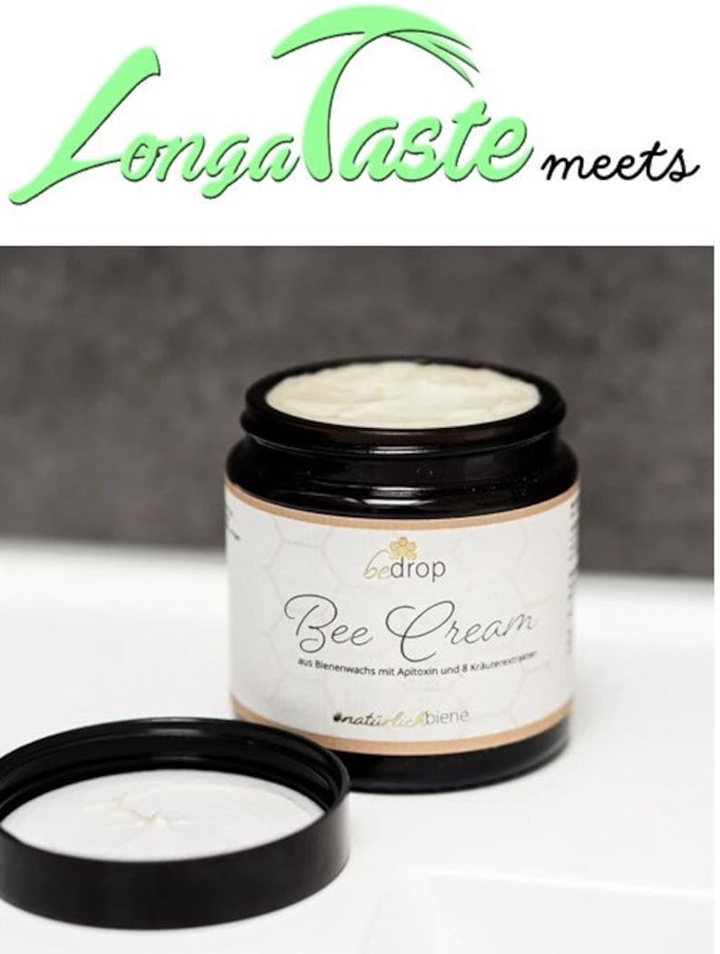 May include: A black jar of "Bee Cream" with a white label and a black lid. The label includes the brand name "bedrop" and the words "Bee Cream" in cursive. The jar is open, revealing the cream inside. The text "Longa Taste meets" is at the top.