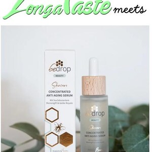 May include: A skincare product set featuring a bottle and a box. The box and bottle are labeled "bedrop BEAUTY Skincare CONCENTRATED ANTI AGING SERUM". The box has a honeycomb and bee design. The bottle has a wooden cap.