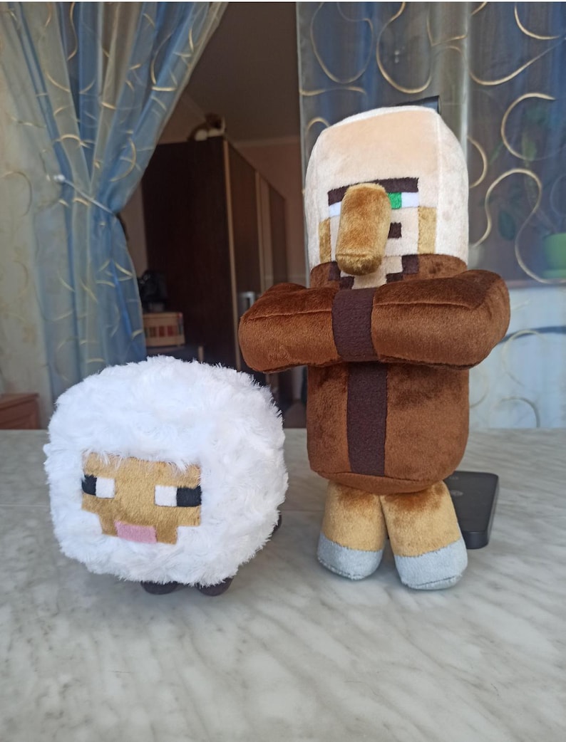 May include: Two plush toys: a white sheep with a pixelated face and a brown and tan Minecraft villager. The sheep has a fluffy body and black, pink, and tan details. The villager has a brown robe, tan face, and pixelated features.