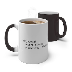 Op de afbeelding: Een witte keramische mok met een zwarte handgreep en binnenkant, voorzien van zwarte codetekst die luidt .ninja_mug{ color: black; visability: hidden; }. Een tweede volledig zwarte mok staat erachter, met stoom uit de voorste mok.