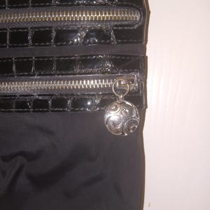 May include: A white ceramic mug with a black handle and the text "But First, Coffee" in a black, handwritten-style font. The mug is on a white surface. The mug is approximately 4 inches tall.