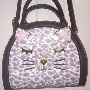 Può includere: Un set di tre tazze in ceramica con finitura opaca e macchiettata. Le tazze sono nei toni del crema, grigio chiaro e grigio scuro. Ogni tazza ha un design semplice e minimalista.