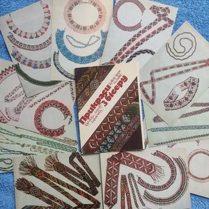 May include: A collection of printed designs for beaded jewelry, including necklaces and bracelets, with a book titled "Прикраси з бісеру" in the center. The designs feature various patterns and colors, showcasing traditional beadwork.