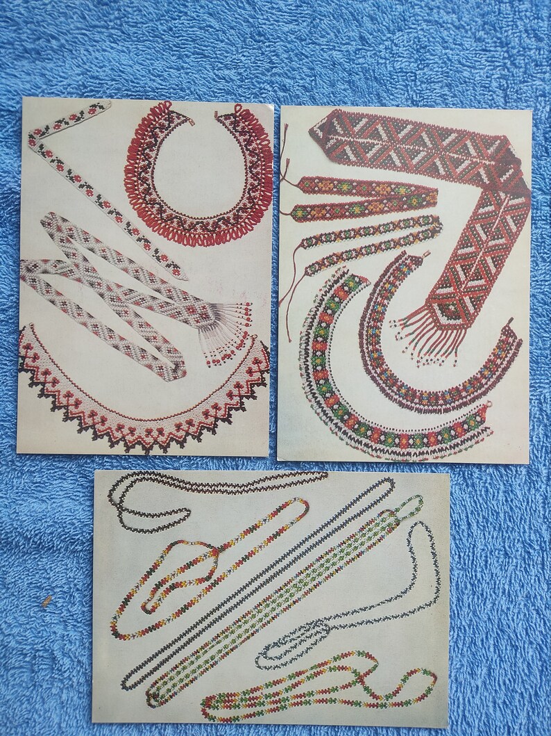 May include: Three vintage postcards showcasing colorful beaded jewelry designs. The cards feature necklaces, bracelets, and decorative bands with intricate patterns in red, white, green, and yellow. The designs are displayed on a cream-colored background.