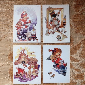 May include: Four vintage postcards featuring colorful illustrations of children in various scenes. The postcards are white with a light blue border and feature a number in the top right corner.