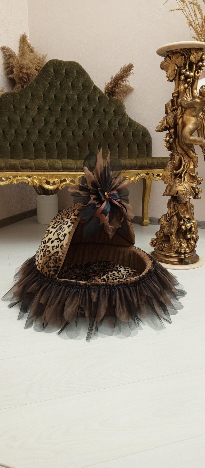 May include: A brown and black leopard print pet bed with a brown tulle skirt and a brown bow on top.