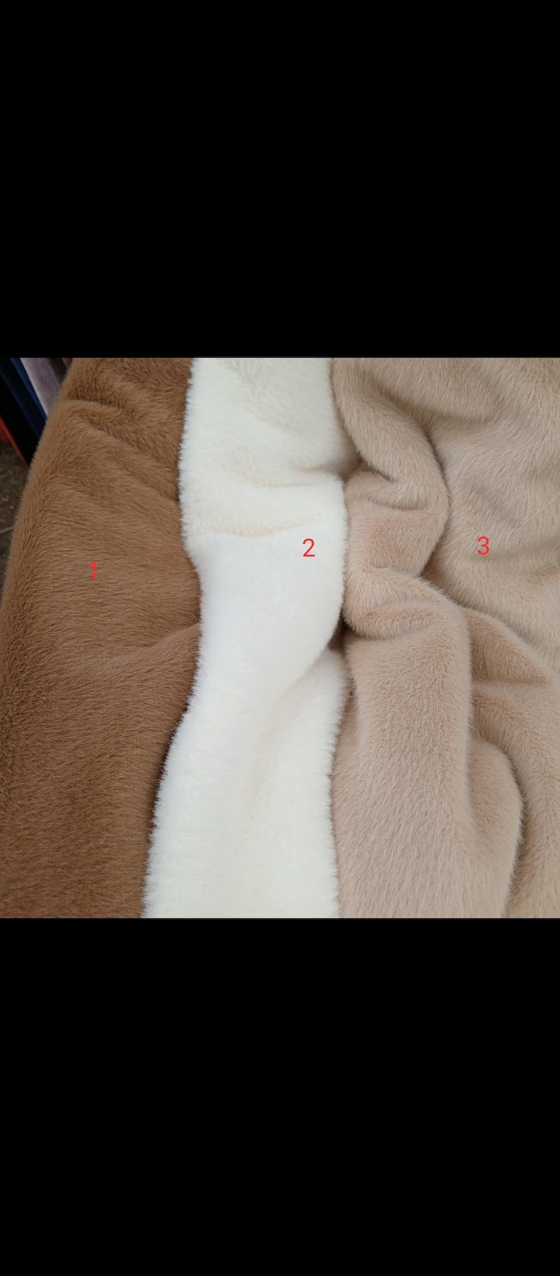 May include: Close-up of three faux fur fabrics in shades of brown, white, and tan. The textures are soft and plush, ideal for crafting or fashion projects. The image highlights the color variations and the tactile quality of the materials.
