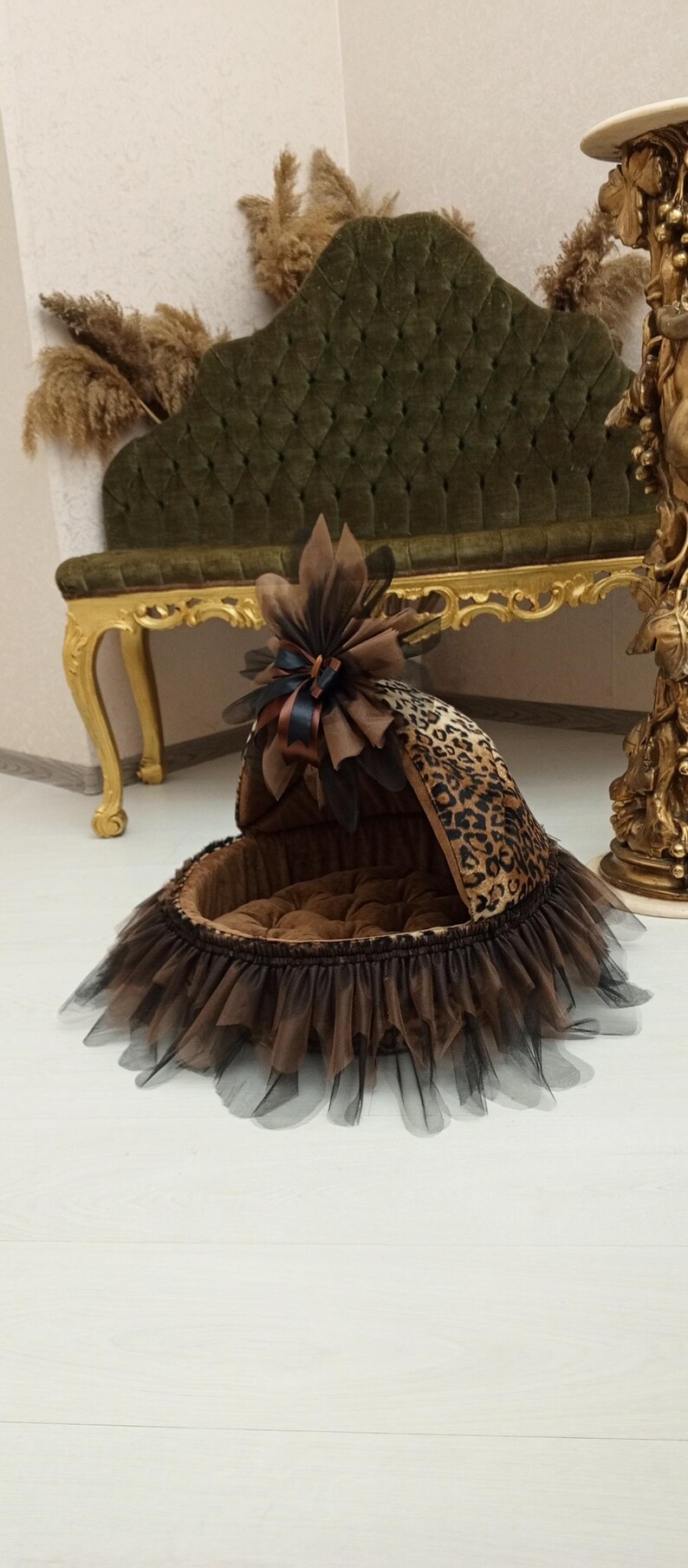 May include: A brown and black leopard print pet bed with a brown and black tulle skirt. The bed has a brown velvet lining and a brown bow with a black ribbon on top.